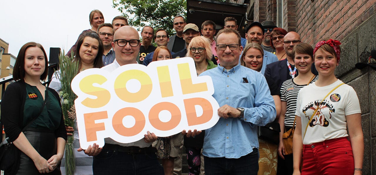 Soilfoodin työntekijät ryhmäkuvassa. Kuva otettu kesällä 2019 Soilfood festareilla.